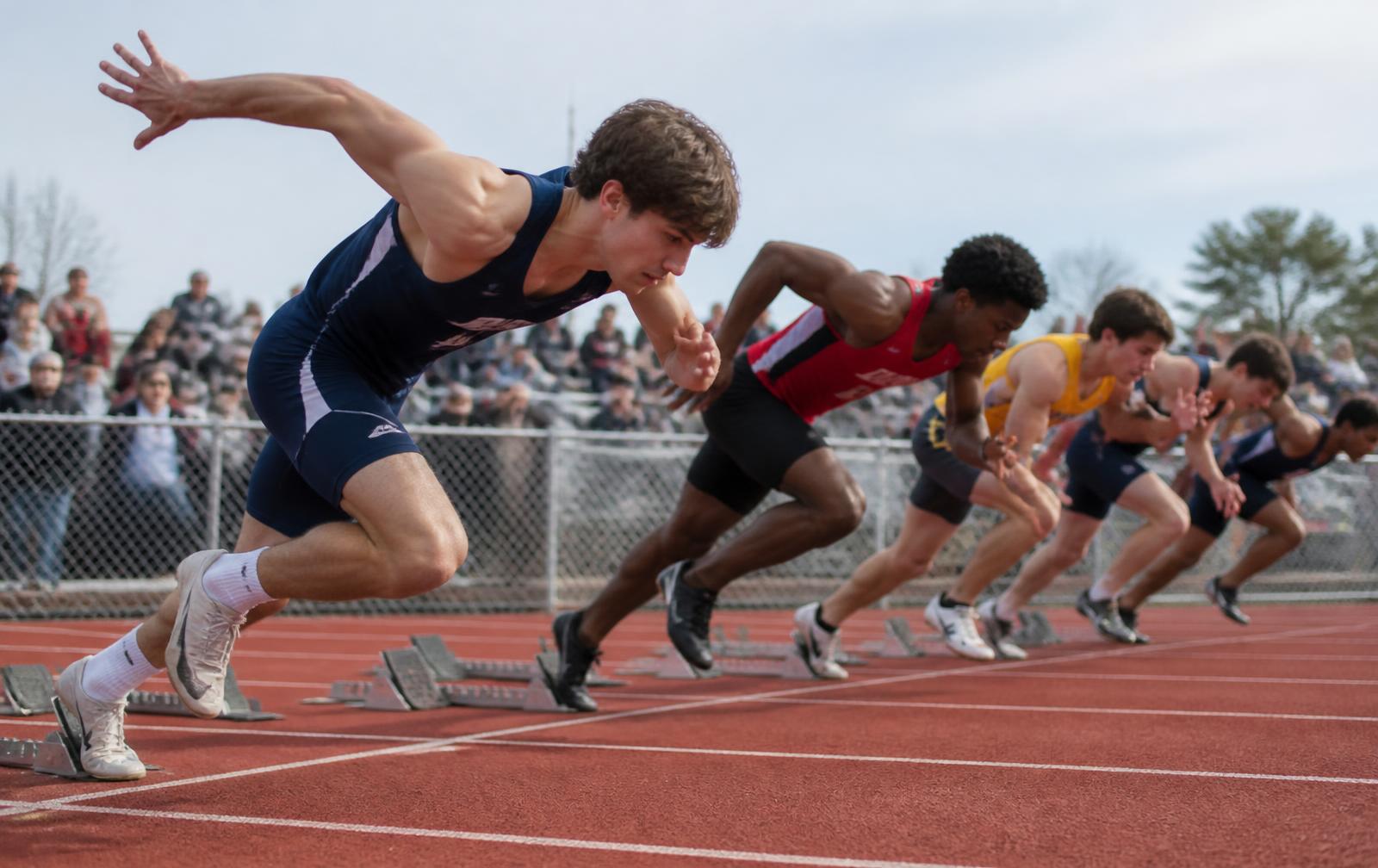 Sprinters exploding out of the starting blocks on a track